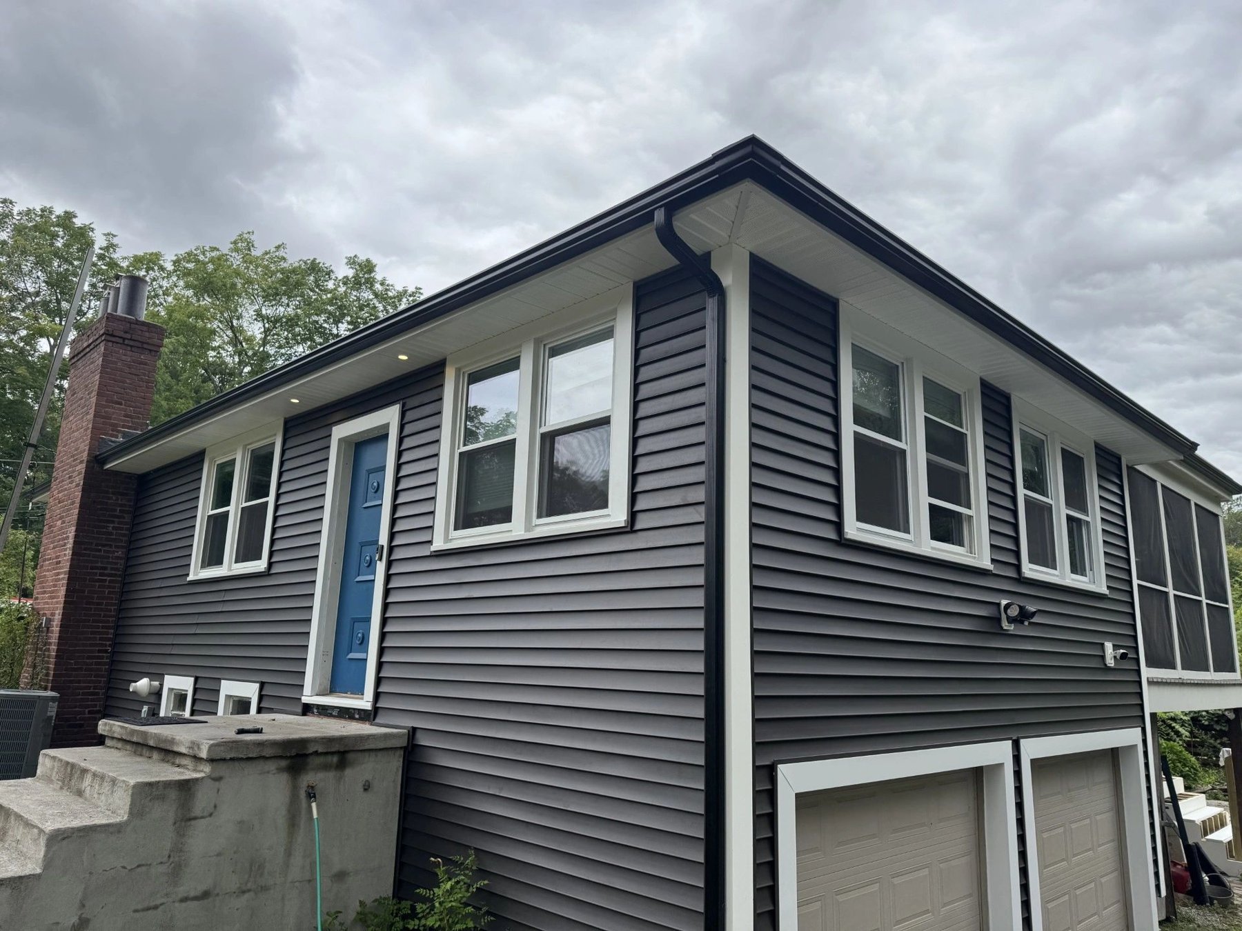 Dark seamless gutter system on a gray house
